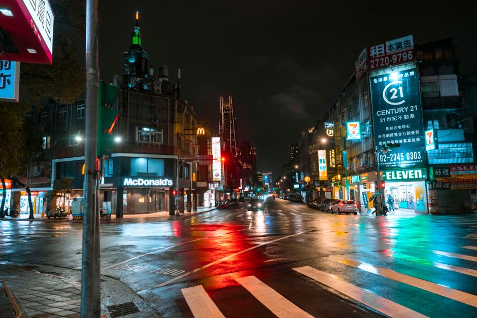 Colorida calle de la ciudad en Taipei por la noche con calles mojadas reflejando luces de neón.
