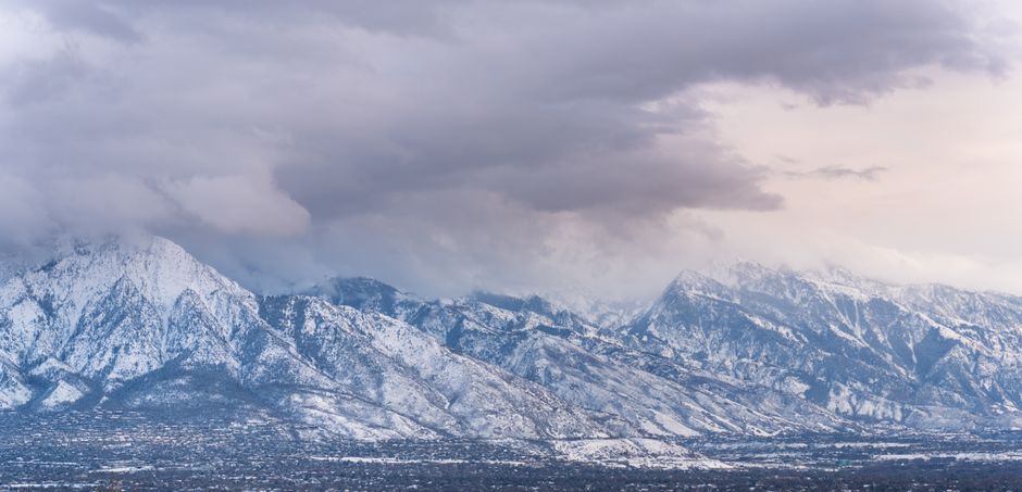 Una vista impresionante de las montañas Wasatch cubiertas de nieve en Salt Lake City, Utah, bajo un cielo dramático.