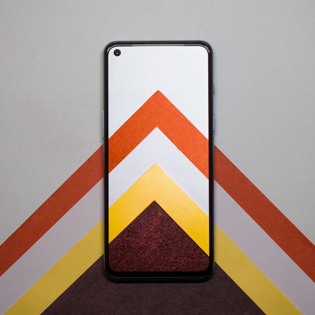 Un smartphone colocado sobre papeles de patrones geométricos coloridos para un aspecto vibrante.