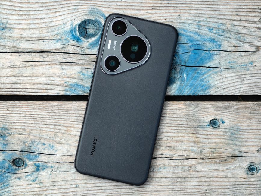 Primer plano de un smartphone moderno colocado sobre una superficie de madera rústica, mostrando el diseño de su cámara.