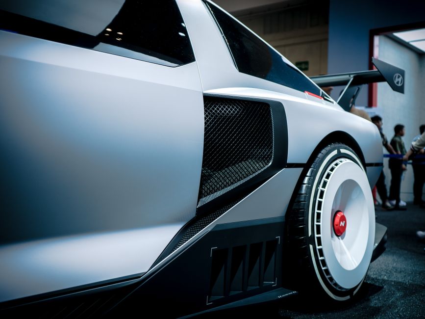 Primer plano de un concept car de Hyundai exhibido en una exposición interior con detalles de diseño modernos.
