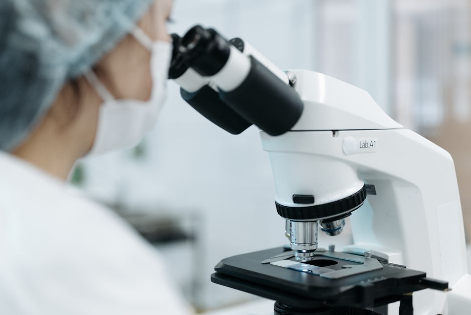 Científico usando un microscopio en un entorno de laboratorio. Enfoque en investigación y análisis.