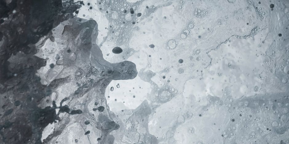 Primer plano de una ola dinámica del océano capturando el movimiento y la textura del chapoteo del agua.