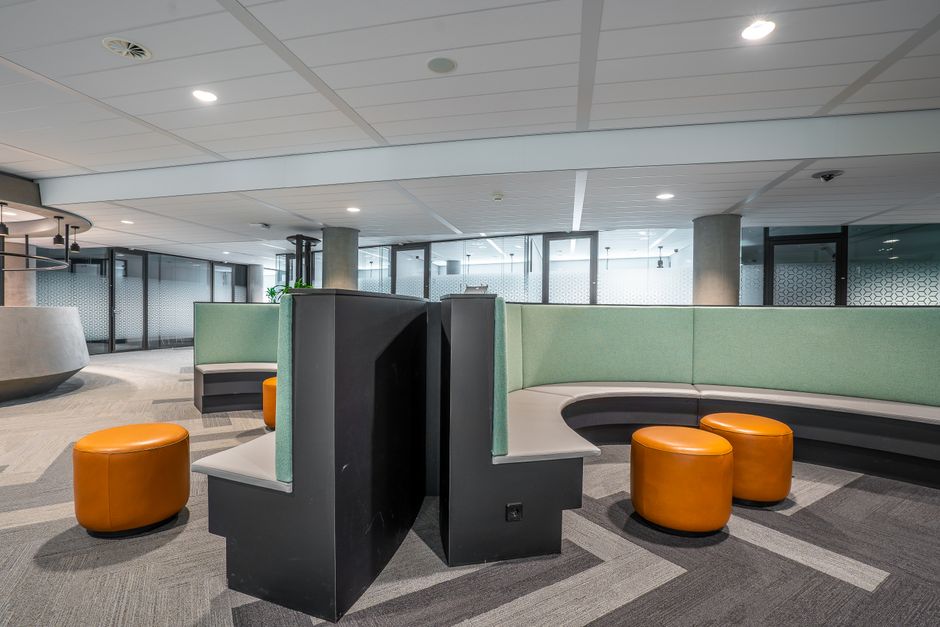 Vestíbulo de oficina contemporáneo con un diseño de asientos únicos y una decoración vibrante para un espacio de trabajo acogedor.