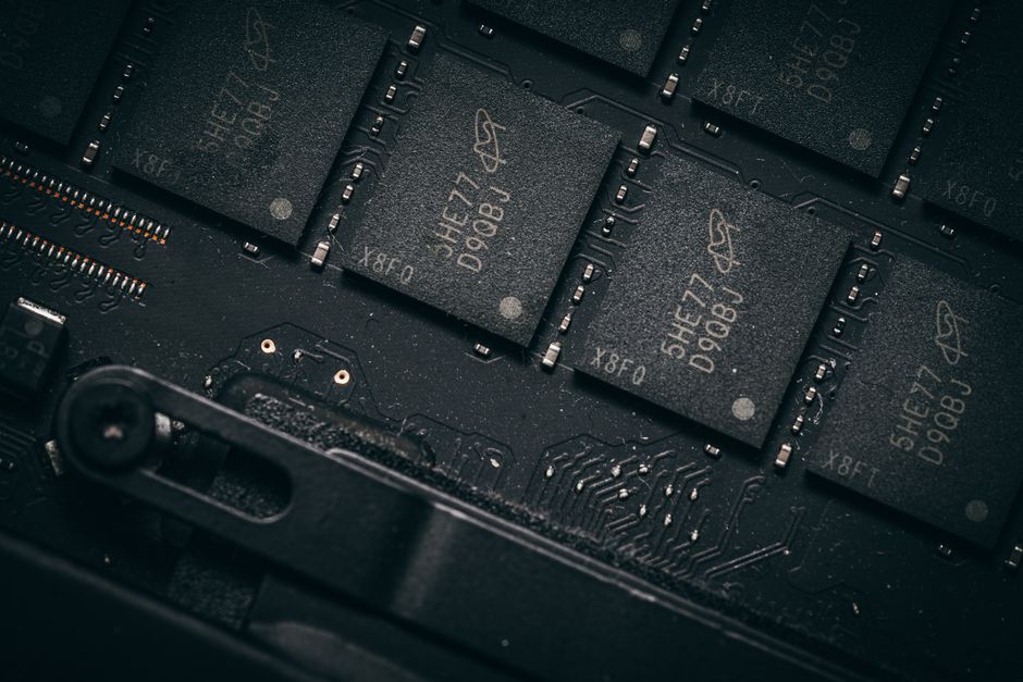 Fotografía detallada de microchips en una placa de circuito, que muestra la tecnología electrónica y la ingeniería de precisión.