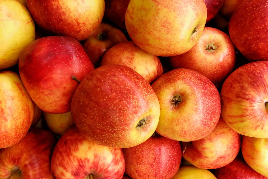 Primer plano de manzanas rojas frescas y vibrantes apiladas, mostrando su atractivo nutritivo.