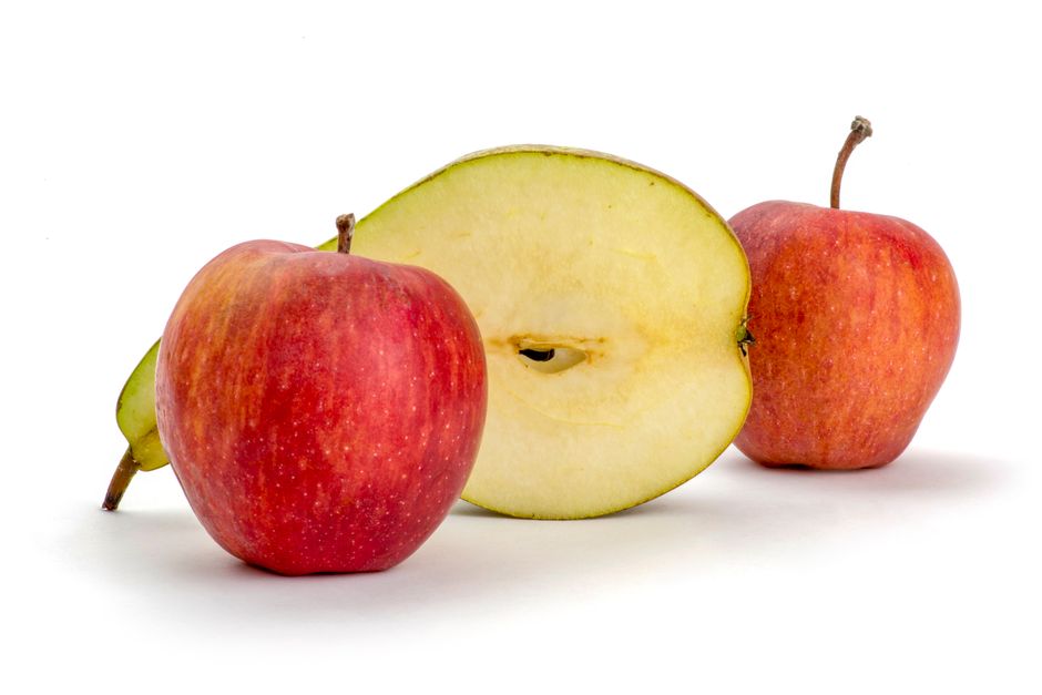Manzanas rojas y una manzana en rodajas sobre un fondo blanco limpio.