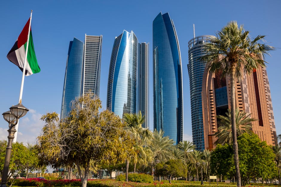 Fotografía cautivadora de las icónicas Torres Etihad, un monumento de Abu Dhabi con palmeras y la bandera de los Emiratos Árabes Unidos.