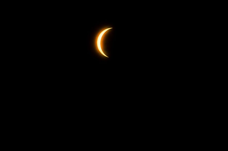 Una imagen enfocada que captura un eclipse solar creciente en Mazatlán, México, de noche.