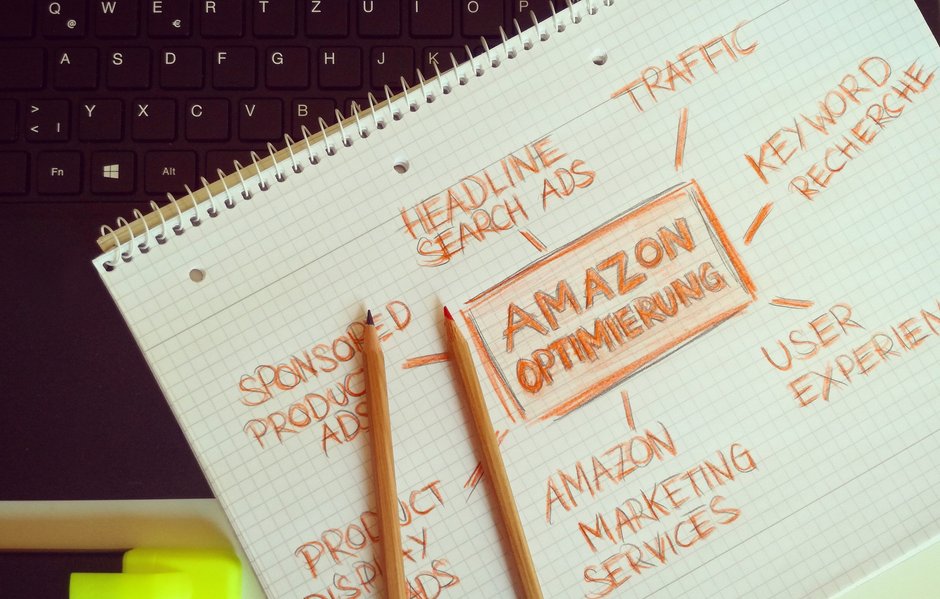 Cuaderno con anotaciones sobre anuncios patrocinados y optimización de Amazon junto a dos lápices.
