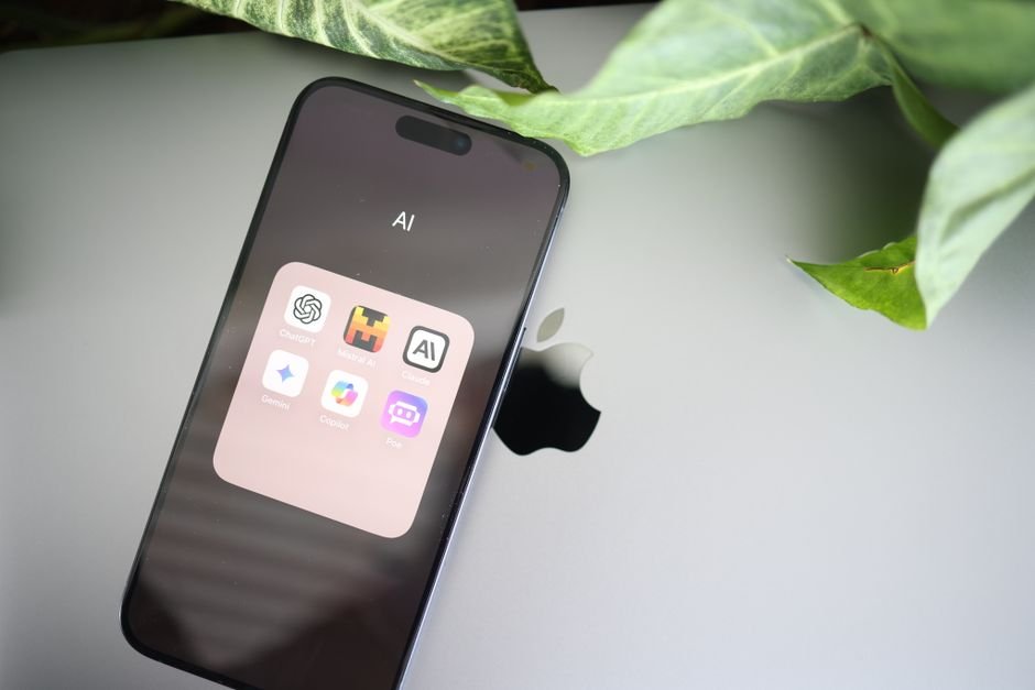 Un smartphone muestra aplicaciones de IA sobre una computadora portátil con el logo de Apple, rodeado de hojas verdes.
