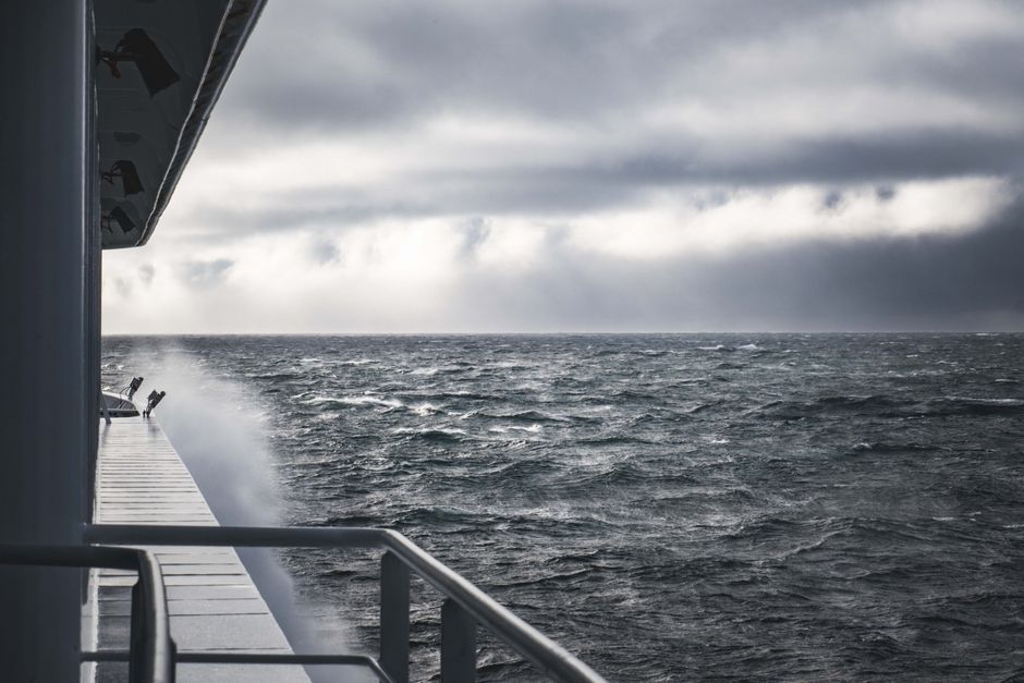 Escena dramática de olas del océano y cielos nublados desde la perspectiva de un barco.