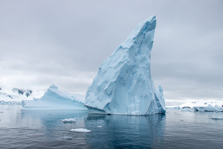 Un imponente iceberg rodeado de tranquilas aguas heladas en la Antártida, que muestra la belleza natural.