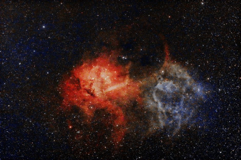 Una vista cautivadora de una colorida nebulosa rodeada de estrellas en una vasta galaxia.