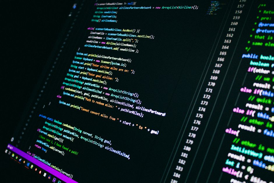 Primer plano de código de programación colorido en una pantalla de ordenador, mostrando tecnología digital.