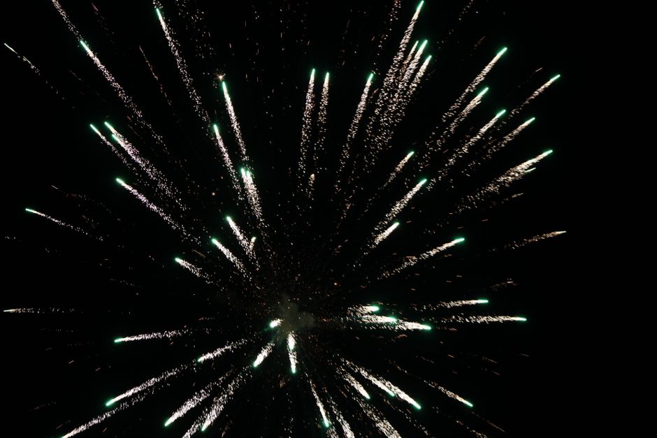 Una impresionante explosión de fuegos artificiales iluminando el cielo nocturno con colores vivos y destellos.