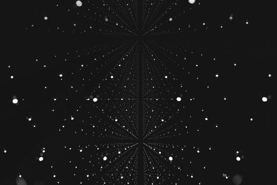 Imagen abstracta en blanco y negro con patrones geométricos que parecen copos de nieve, creando un efecto de noche estrellada.