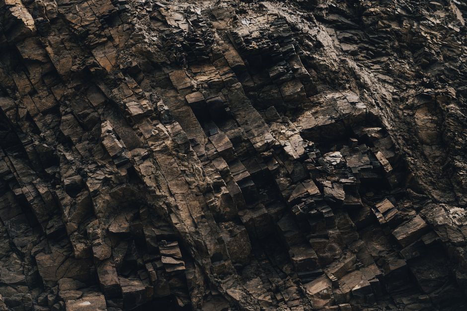 Vista en primer plano de una formación rocosa natural irregular que muestra capas texturizadas y tonos terrosos.