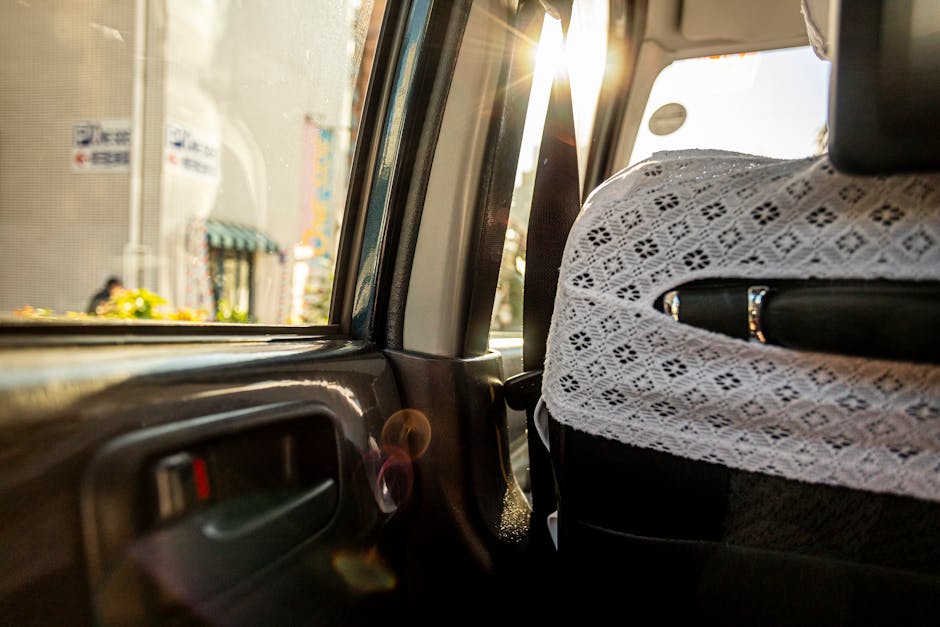 La luz del sol ilumina el interior de un taxi con asientos con fundas de encaje, capturando un momento sereno.