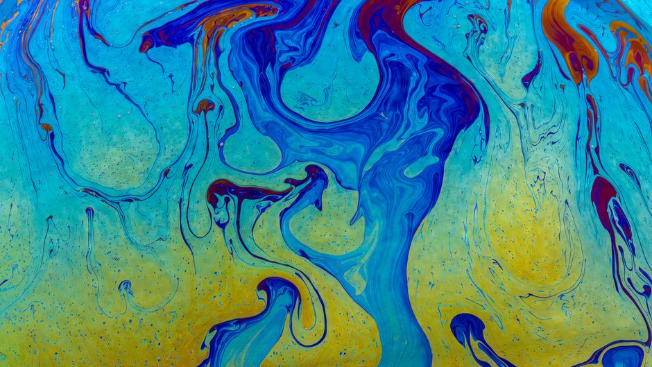 Pieza de arte abstracto dinámica con patrones fluidos azules y amarillos vibrantes, que crean una textura brillante y creativa.
