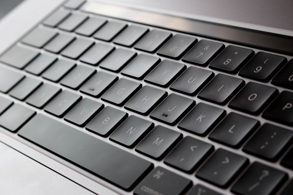 Primer plano detallado de un teclado moderno de laptop con diseño elegante y teclas retroiluminadas.
