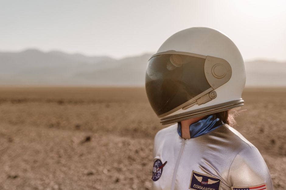 Astronauta en un traje espacial de pie en un paisaje desértico árido que se asemeja a Marte.