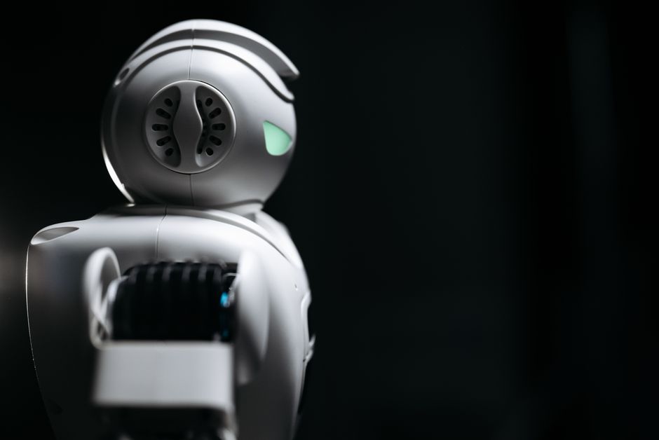 Primer plano de un robot futurista en un entorno de estudio oscuro, mostrando innovación y tecnología.