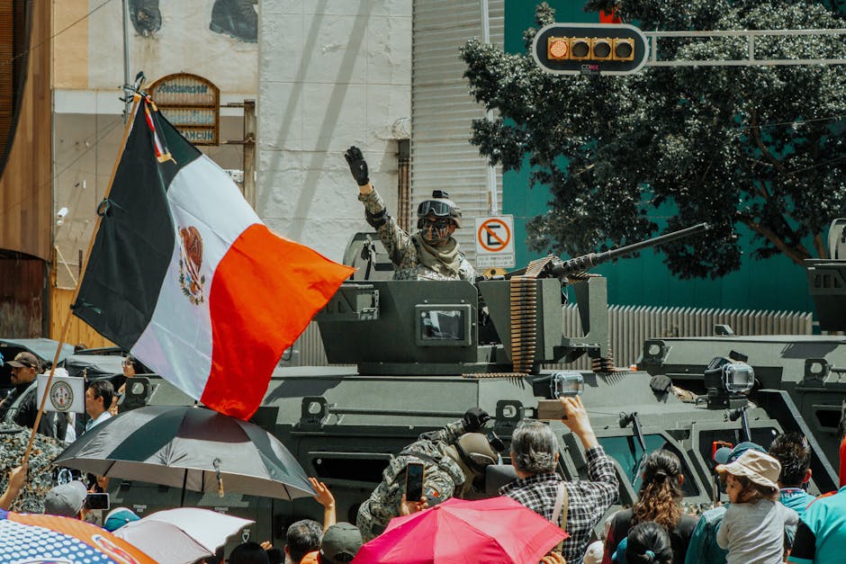 Un vibrante desfile militar en la Ciudad de México que muestra un vehículo blindado y la bandera mexicana.