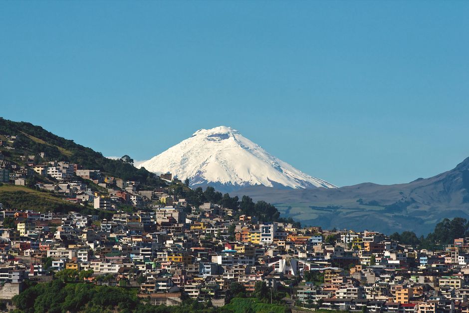 Explora Quito con el majestuoso telón de fondo del Volcán Cotopaxi bajo un cielo azul claro.