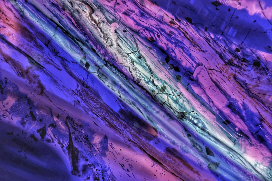 Imagen abstracta vibrante con patrones dinámicos de luz púrpura y azul.