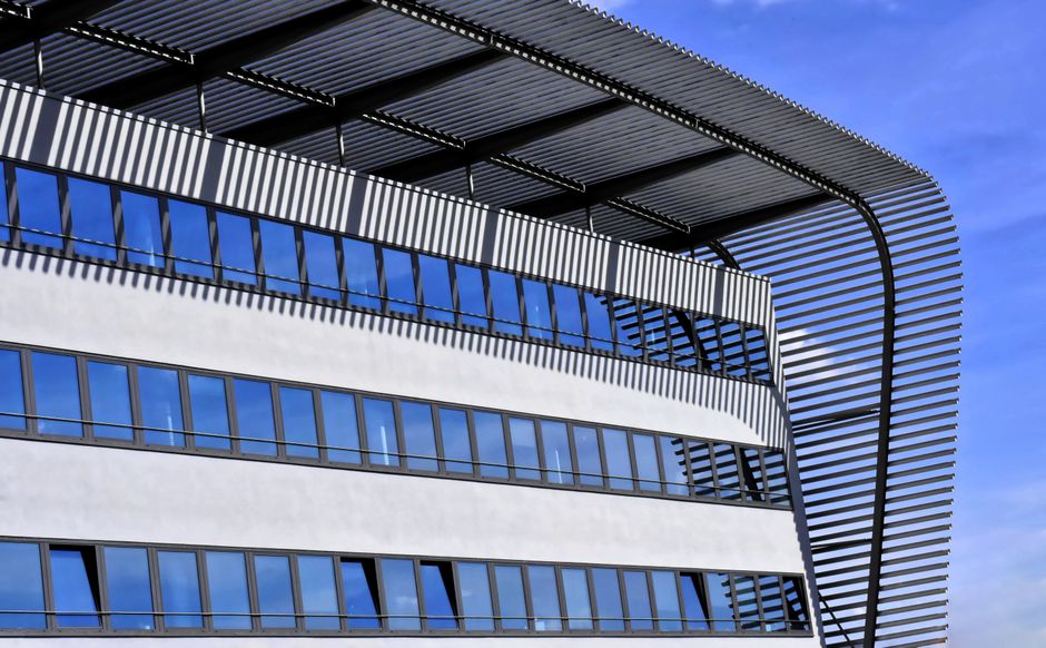 Primer plano de un edificio contemporáneo con ventanas de cristal y diseño de techo de acero.