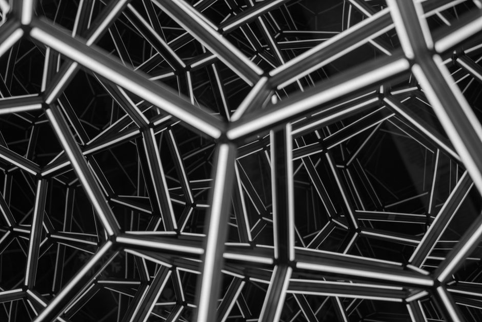 Patrón geométrico en blanco y negro con líneas intersecadas, creando un efecto visual abstracto y complejo.
