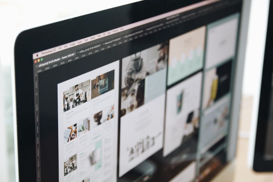 Una pantalla de computadora moderna mostrando trabajos de diseño web, exhibiendo visuales creativos en un espacio de trabajo.