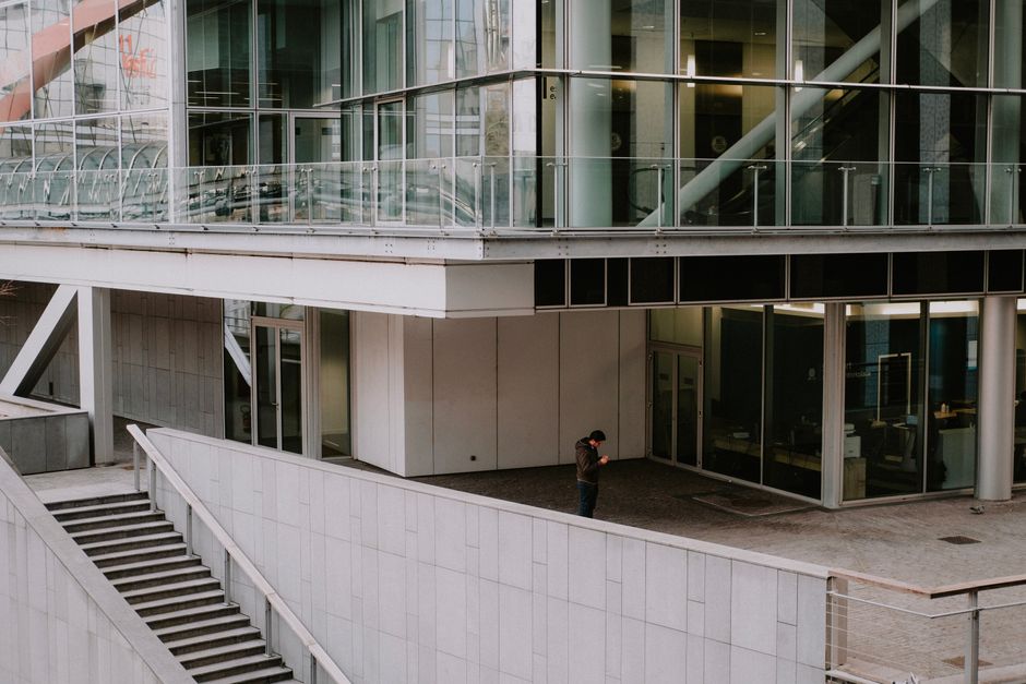 Arquitectura contemporánea de la ciudad con un hombre solo de pie cerca de las escaleras. Escena urbana moderna.