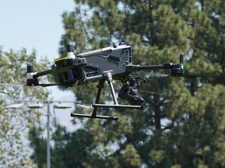 Un dron moderno que vuela al aire libre mostrando tecnología y diseño avanzados.