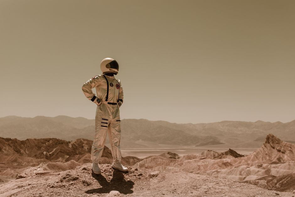 Astronauta en un paisaje desolado, evocando exploración sci-fi en otro planeta.