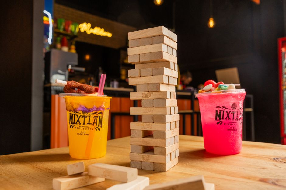 Bebidas coloridas con set de Jenga en Mixtlán, perfectas para reuniones sociales.