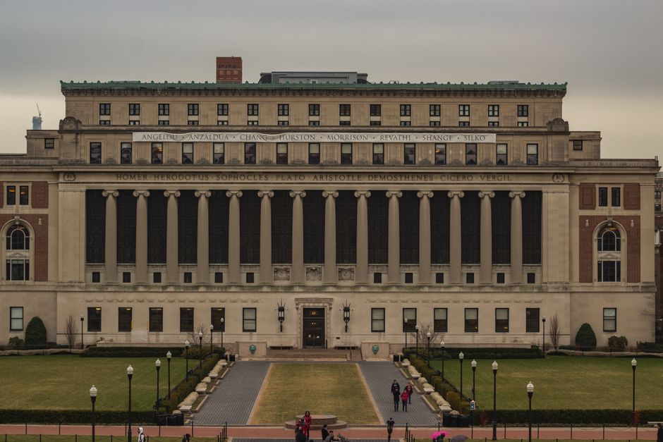 Fachada elegante de una biblioteca universitaria histórica con arquitectura clásica.