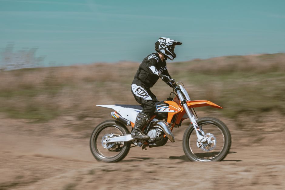 Un motocilista en acción en una pista de tierra, mostrando velocidad y agilidad en una emocionante carrera de motocross.