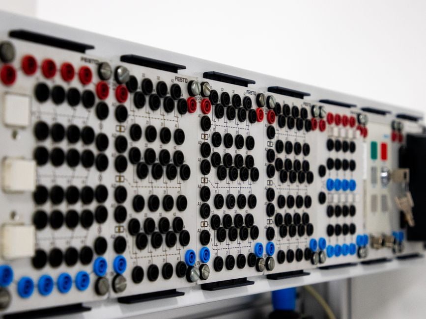 Imagen detallada de un panel de control industrial moderno que cuenta con múltiples conectores y botones.