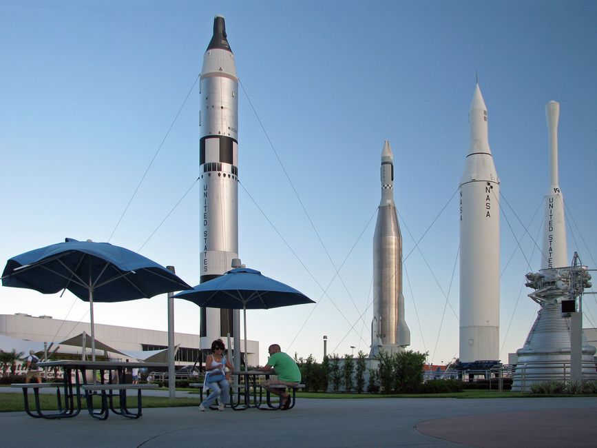 Una pareja se sienta bajo sombrillas con cohetes de la NASA de fondo.