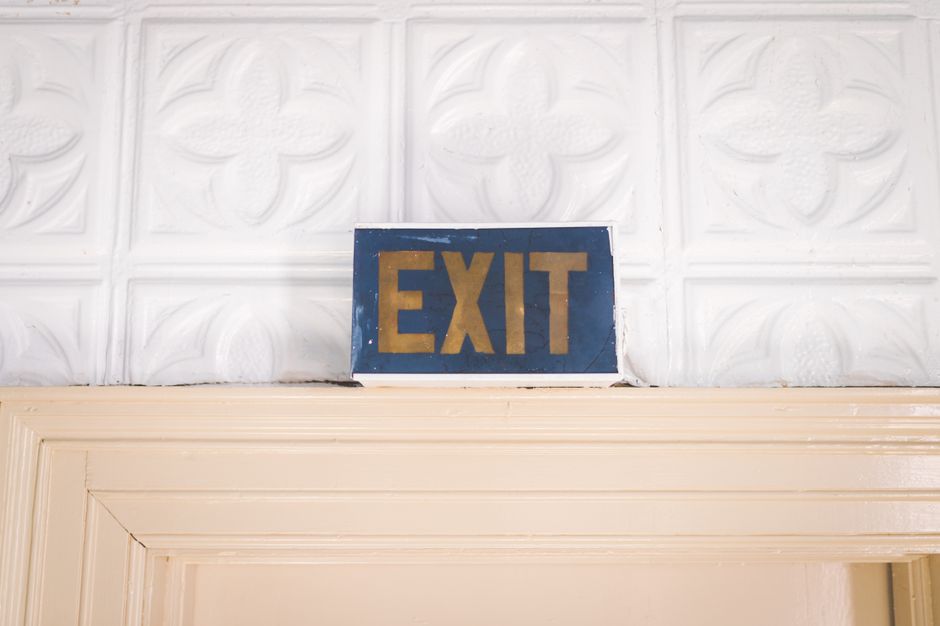 Cartel de salida antiguo con un estilo retro sobre una puerta de madera en el interior.