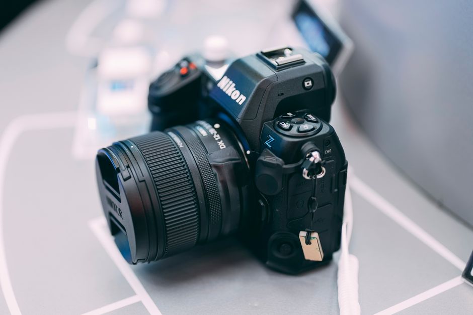 Una cámara DSLR con lente sobre una mesa, mostrando equipo moderno de fotografía.