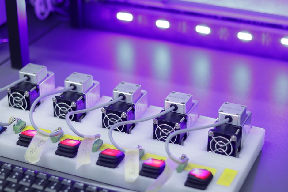 Primer plano detallado de unidades láser CNC con controles brillantes, listas para tareas de precisión.