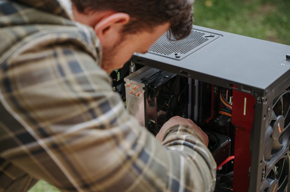 Un hombre limpia y mantiene una PC de escritorio al aire libre con precisión.