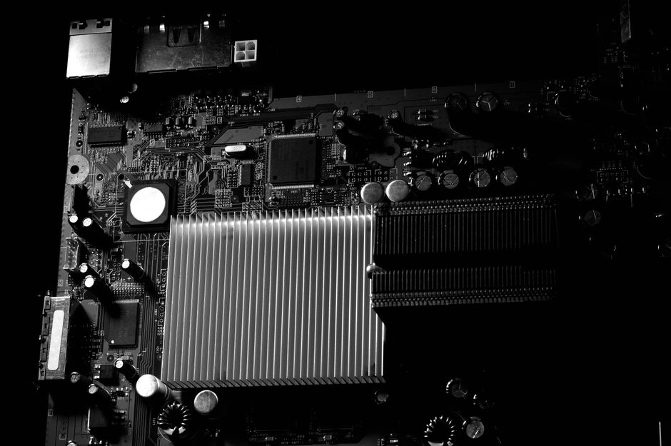 Foto detallada en blanco y negro de una placa base de computadora destacando el disipador.