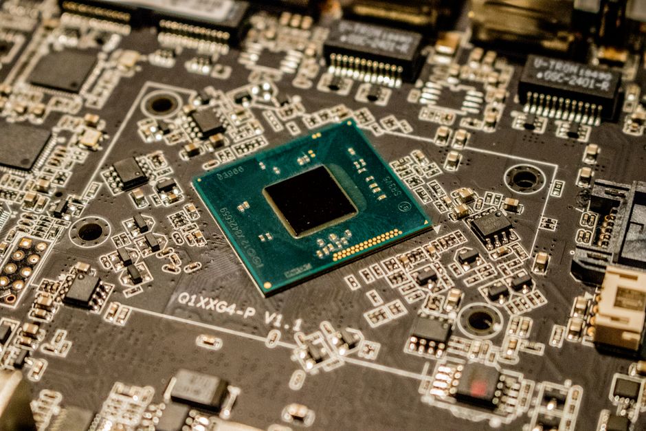 Vista detallada de un microchip en una placa de circuito impreso, mostrando componentes electrónicos.