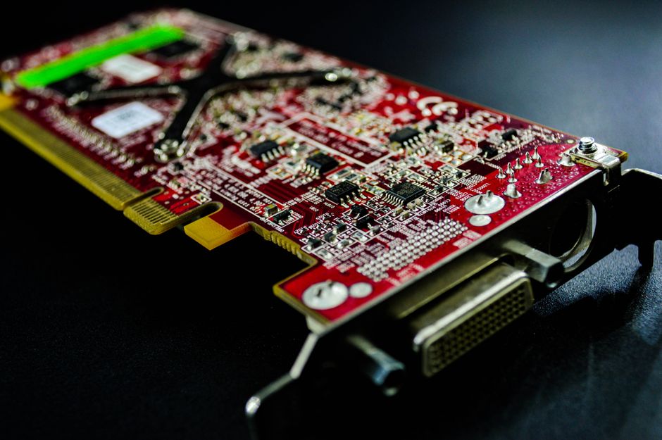 Primer plano detallado de una placa de circuito roja resaltando componentes electrónicos y conectores.