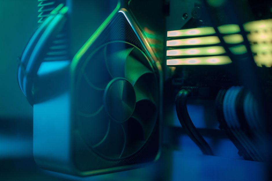 Acercamiento detallado de un ventilador de enfriamiento de computadora dentro de una PC personalizada con iluminación LED, enfatizando la tecnología y el diseño.