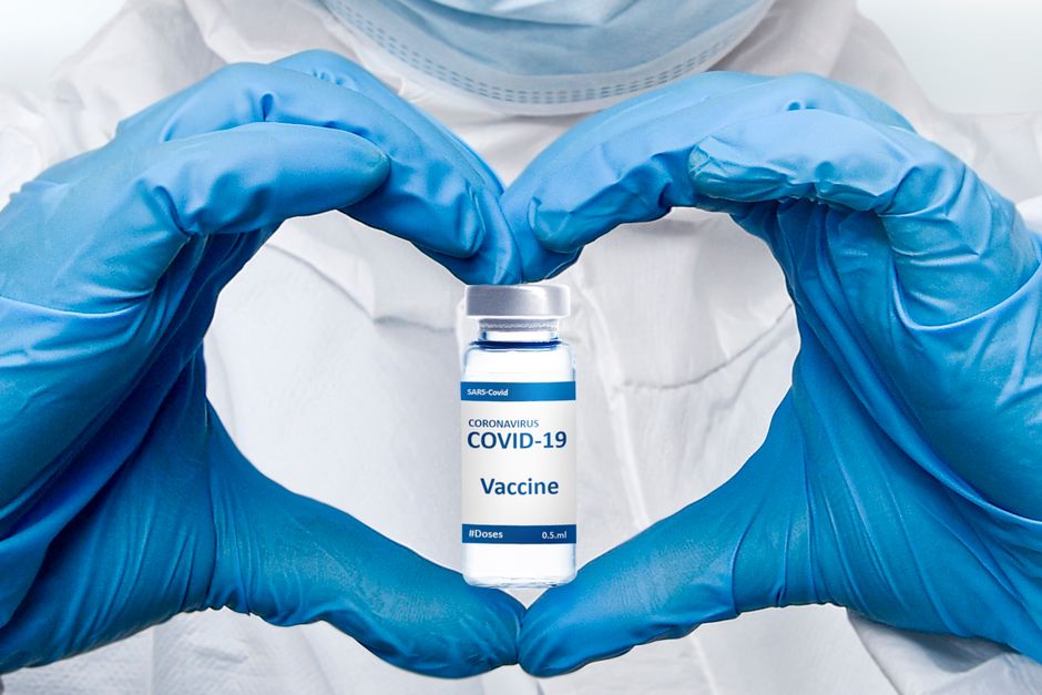 Un profesional de salud con guantes sostiene un vial de vacuna COVID-19, enfatizando la protección y el cuidado médico.